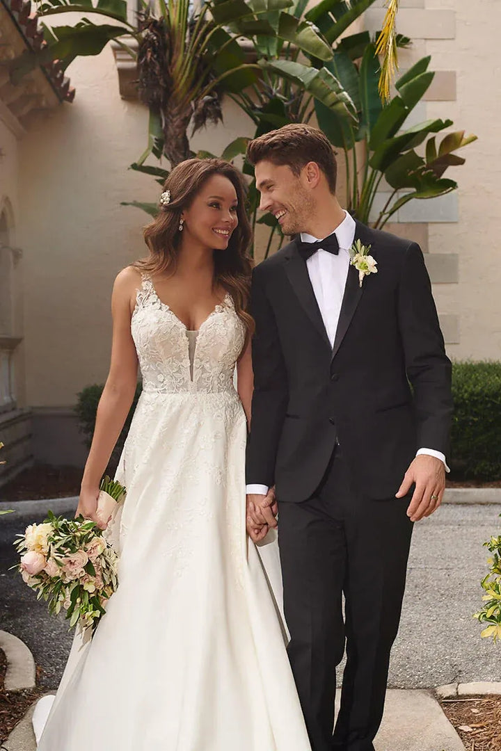 close up of stella york 7198 ivory satin ball gown showing cascading floral lace appliques on the deep v neckline bodice