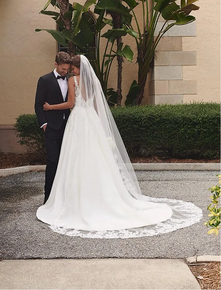 full back of stella york 7198 ivory satin ball gown featuring cascading floral lace appliques and a chapel length train