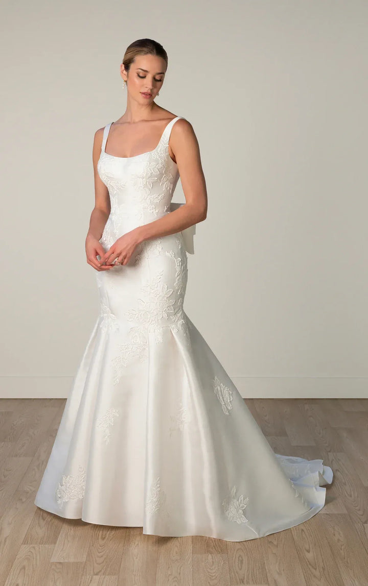Woman wearing a white wedding dress with a plain background