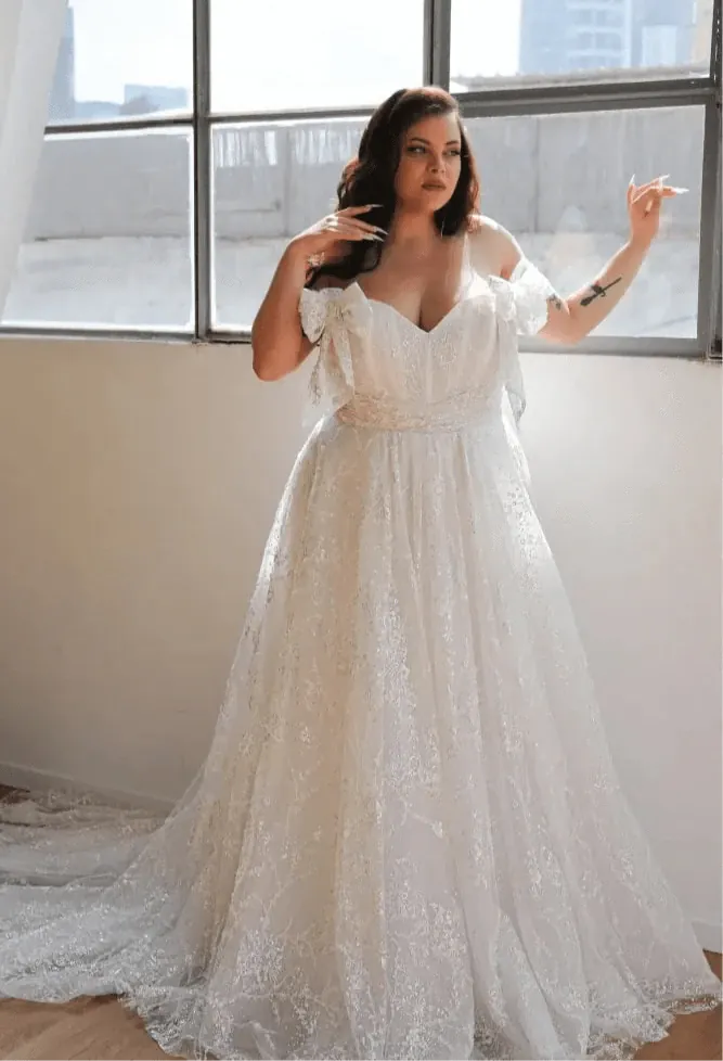 front of studio levana anna ivory lace a-line wedding dress with sweetheart neckline ad bow accents on the straps