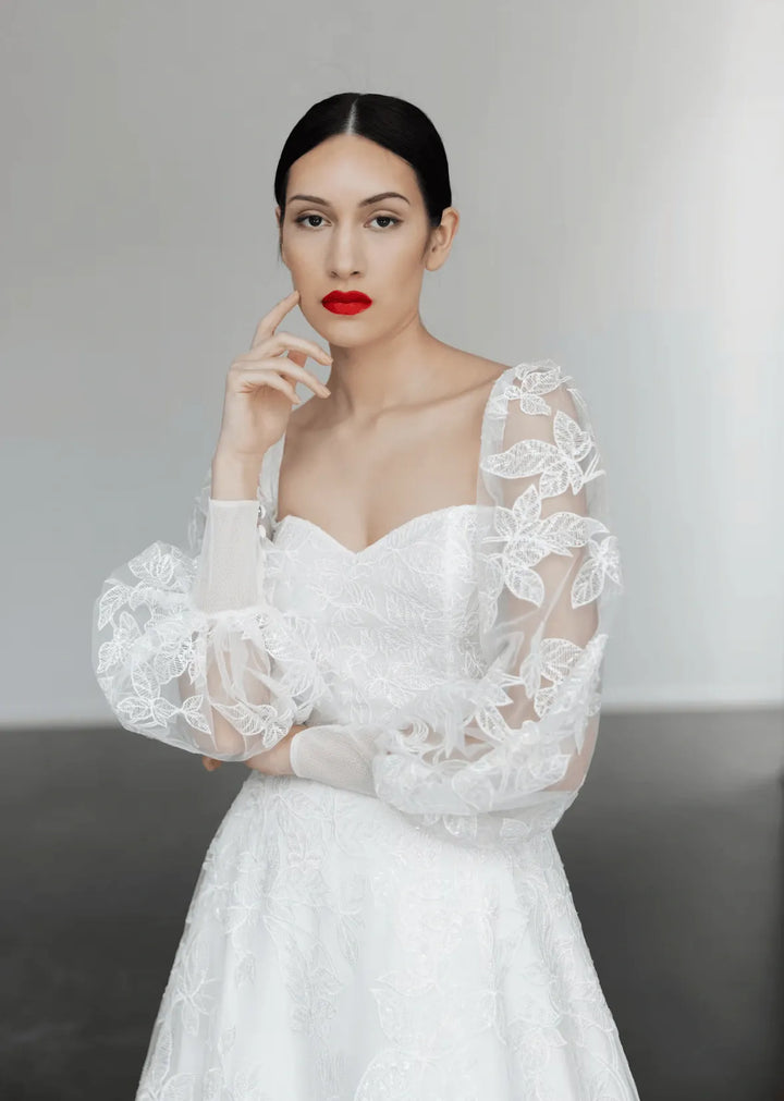 close up of tara latour georgie ivory lace a-line wedding dress with a sweetheart neckline and long billowing sleeves