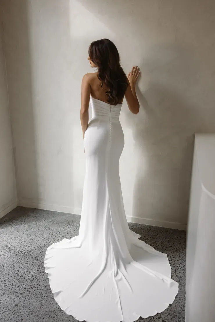 full back of trish peng ari ivory chiffon fitted wedding dress with a draped bodice and strapless neckline