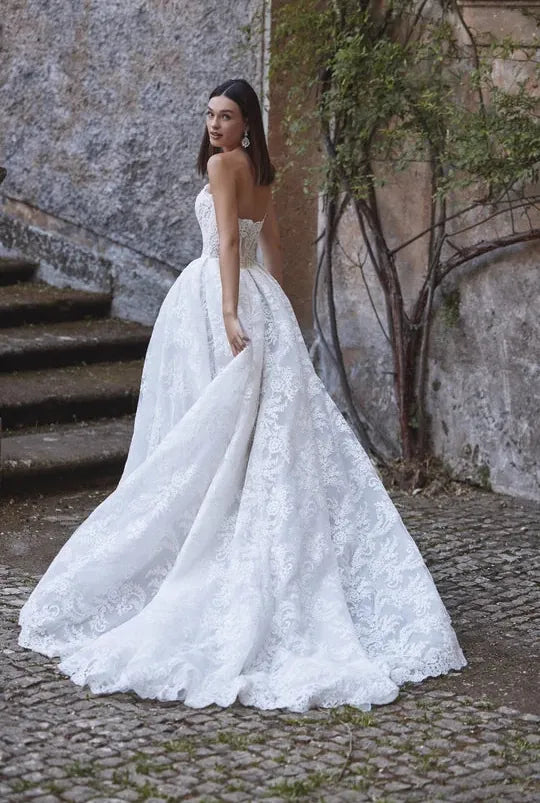 full back of veni infantino ayra ivory lace ball gown wedding dress featuring a long train with a scalloped lace edge