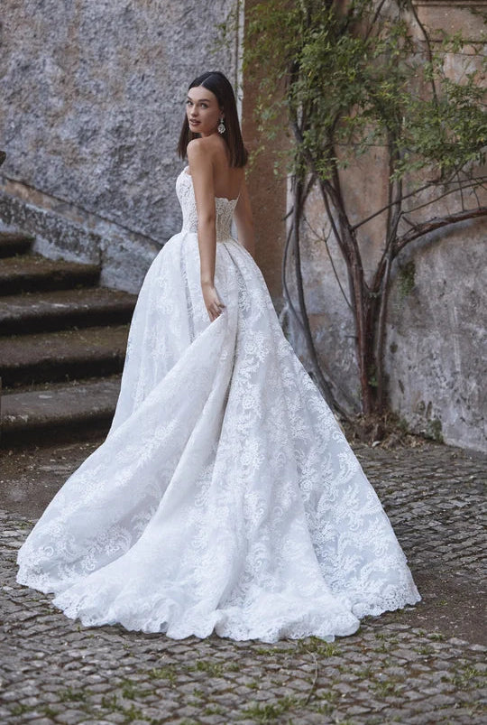 full back of veni infantino ayra ivory lace ball gown wedding dress featuring a long train with a scalloped lace edge