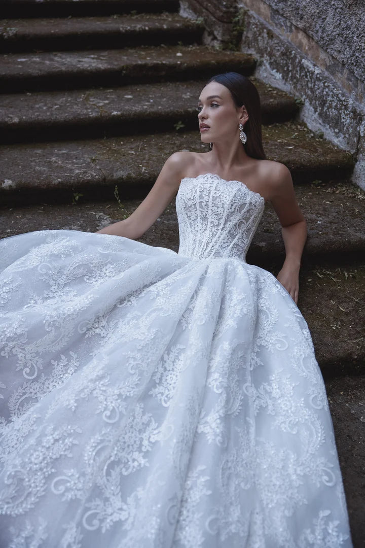 close up of veni infantino ayra ivory lace ball gown wedding dress showing the basque waist and strapless bodice
