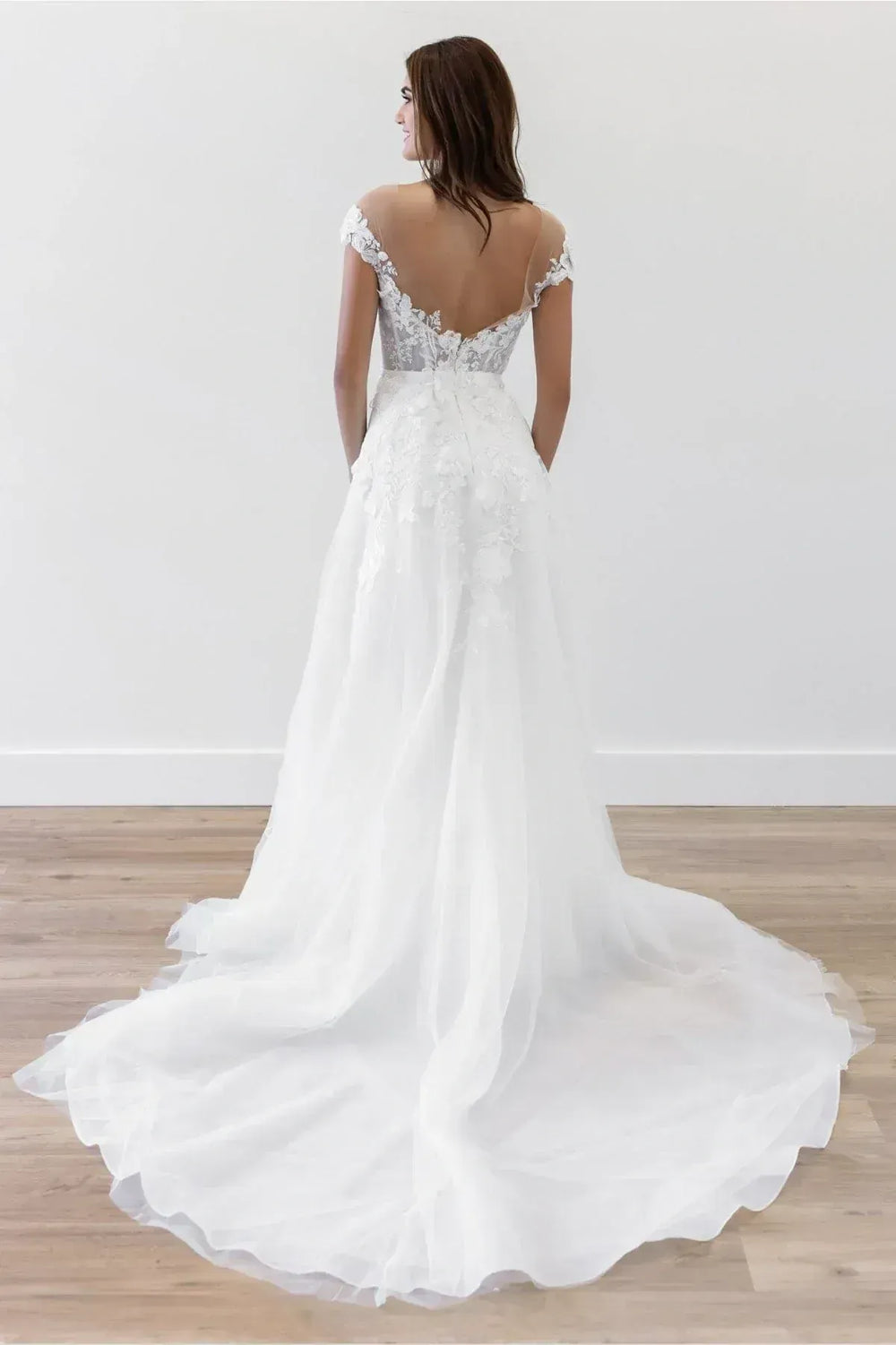 White wedding dress with lace detailing on a wooden floor