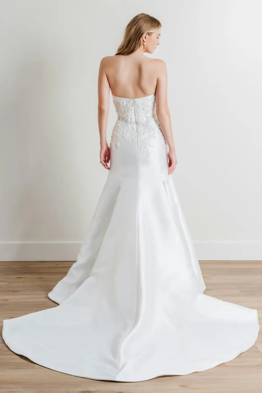 full back of watters ashmore ivory mikado fit and flare wedding dress with floral accents and a long train