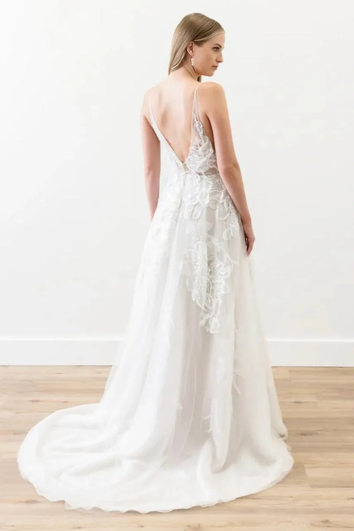 White wedding dress with floral details on a wooden floor