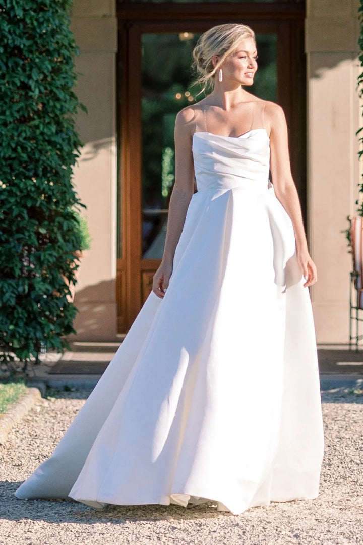 Woman wearing a strapless white wedding dress outdoors.