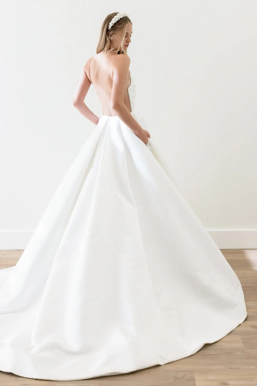 Woman wearing a white wedding dress with a plain background