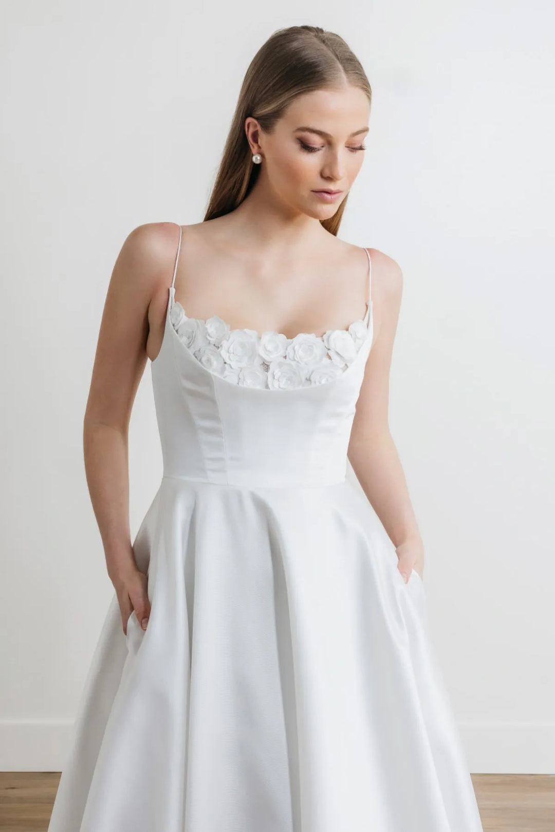 close up of watters hughes ivory mikado a-line wedding dress showing the scoop neck bodice with floral lace and thin straps