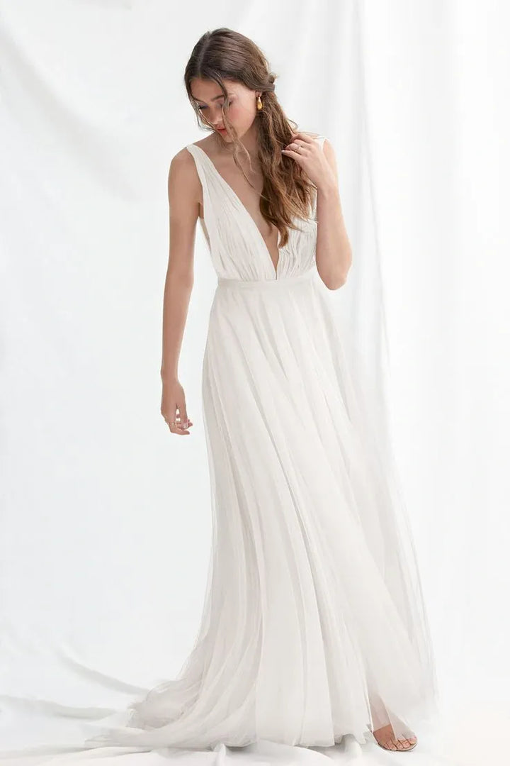 Woman wearing a white dress with a deep neckline against a white background