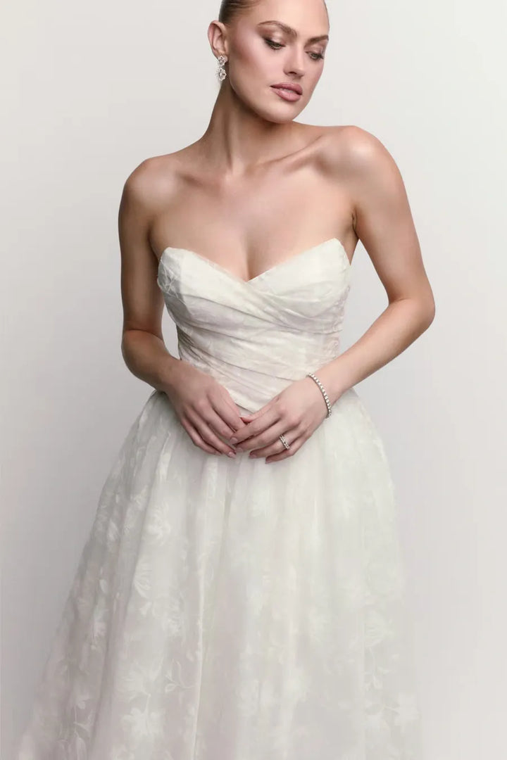 close up of watters isa ivory lace ball gown wedding dress with a drop waist and strapless neckline