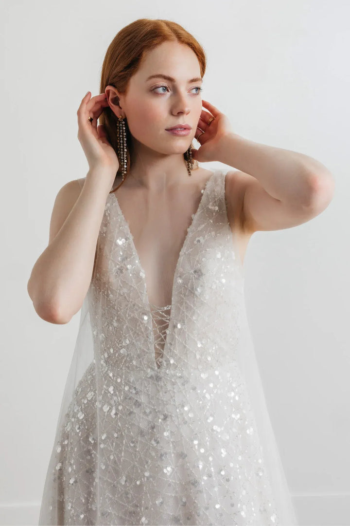 close up of willowby by watters odessa platinum beaded a-line wedding dress with a deep v neckline, shown with the matching cape