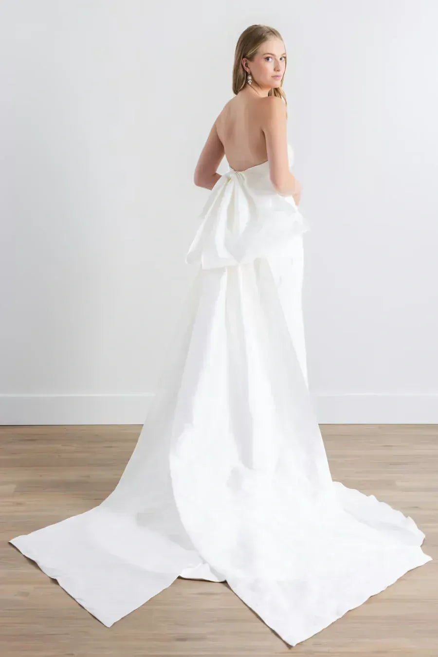 full back of watters sanora ivory crepe fitted wedding dress featuring a detachable bow train