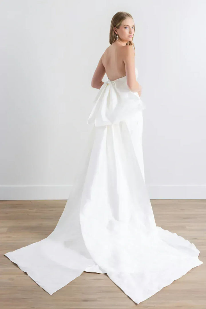 full back of watters sanora ivory crepe fitted wedding dress featuring a detachable bow train