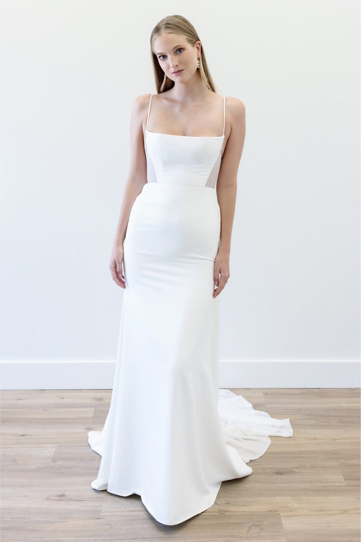 Woman wearing a white wedding dress on a plain background