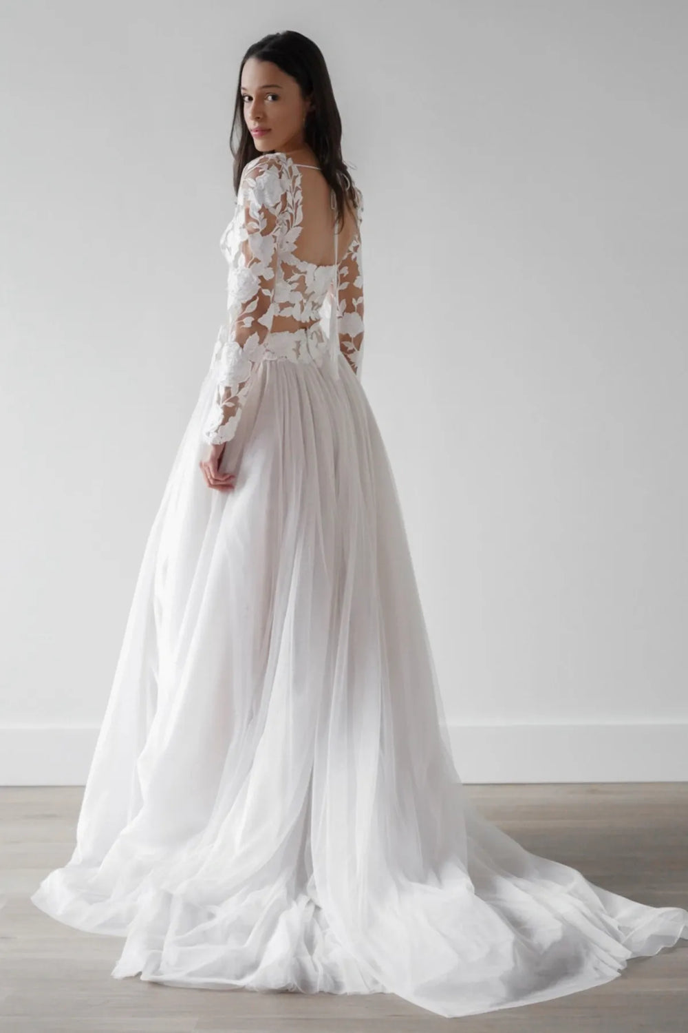 White wedding dress with lace detailing on a plain background