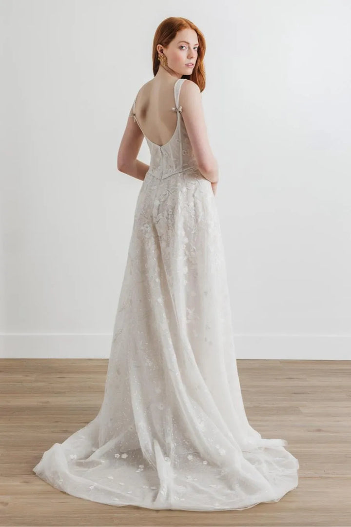 full back of willowby by watters nerissa ivory net sheath wedding dress featuring an open back and short train