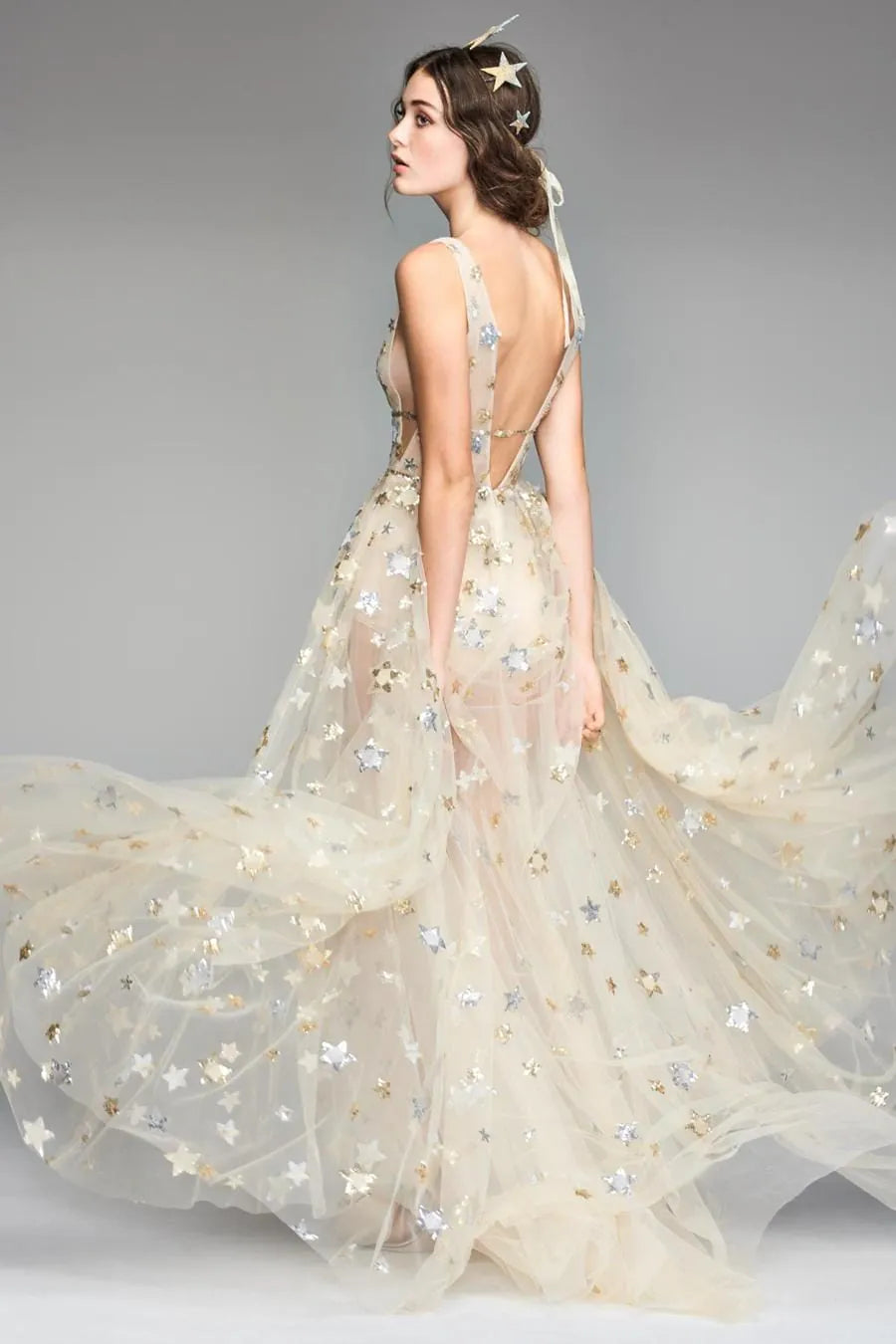 Woman wearing a star-patterned gown on a gray background