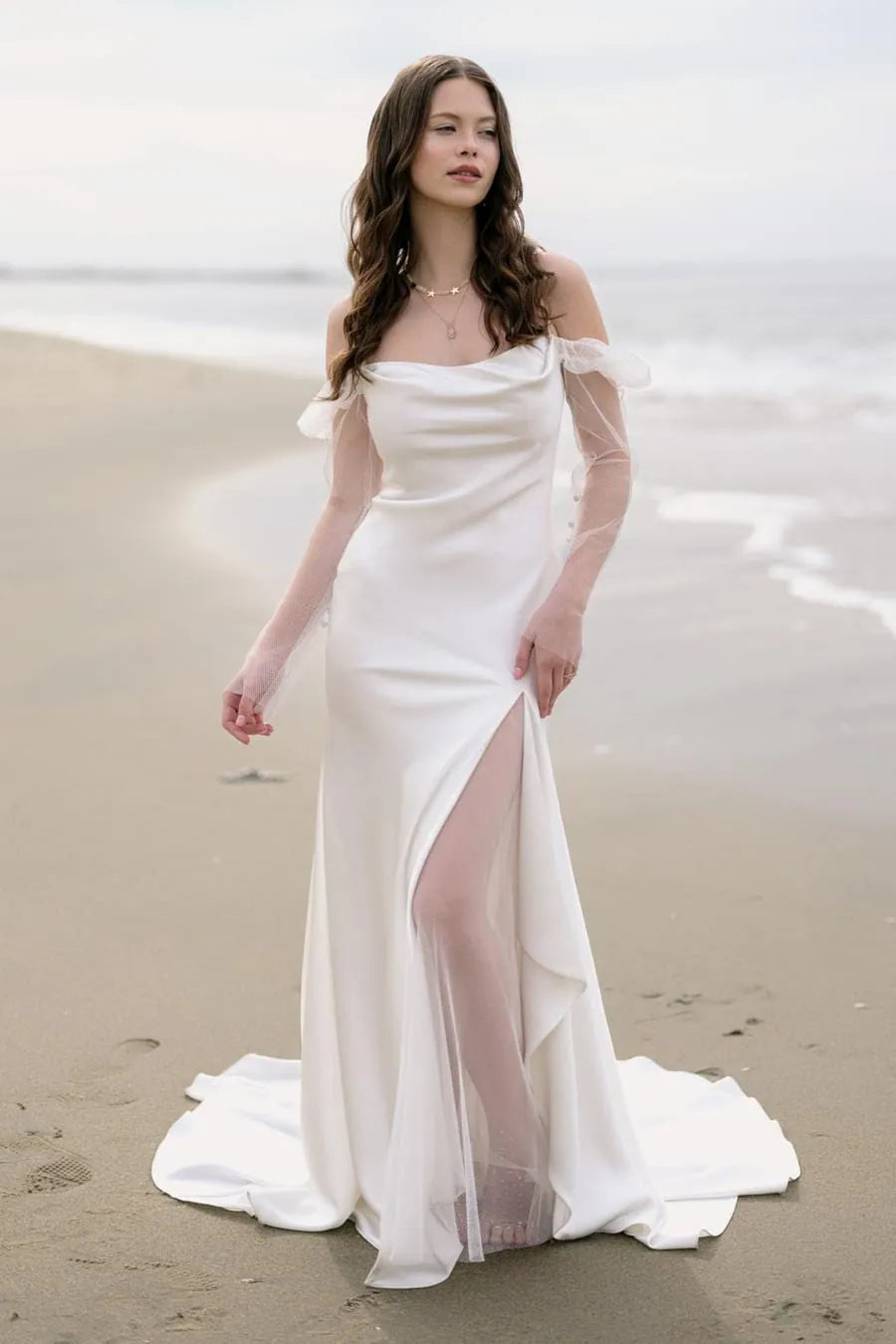 Woman in a white wedding dress standing on a beach