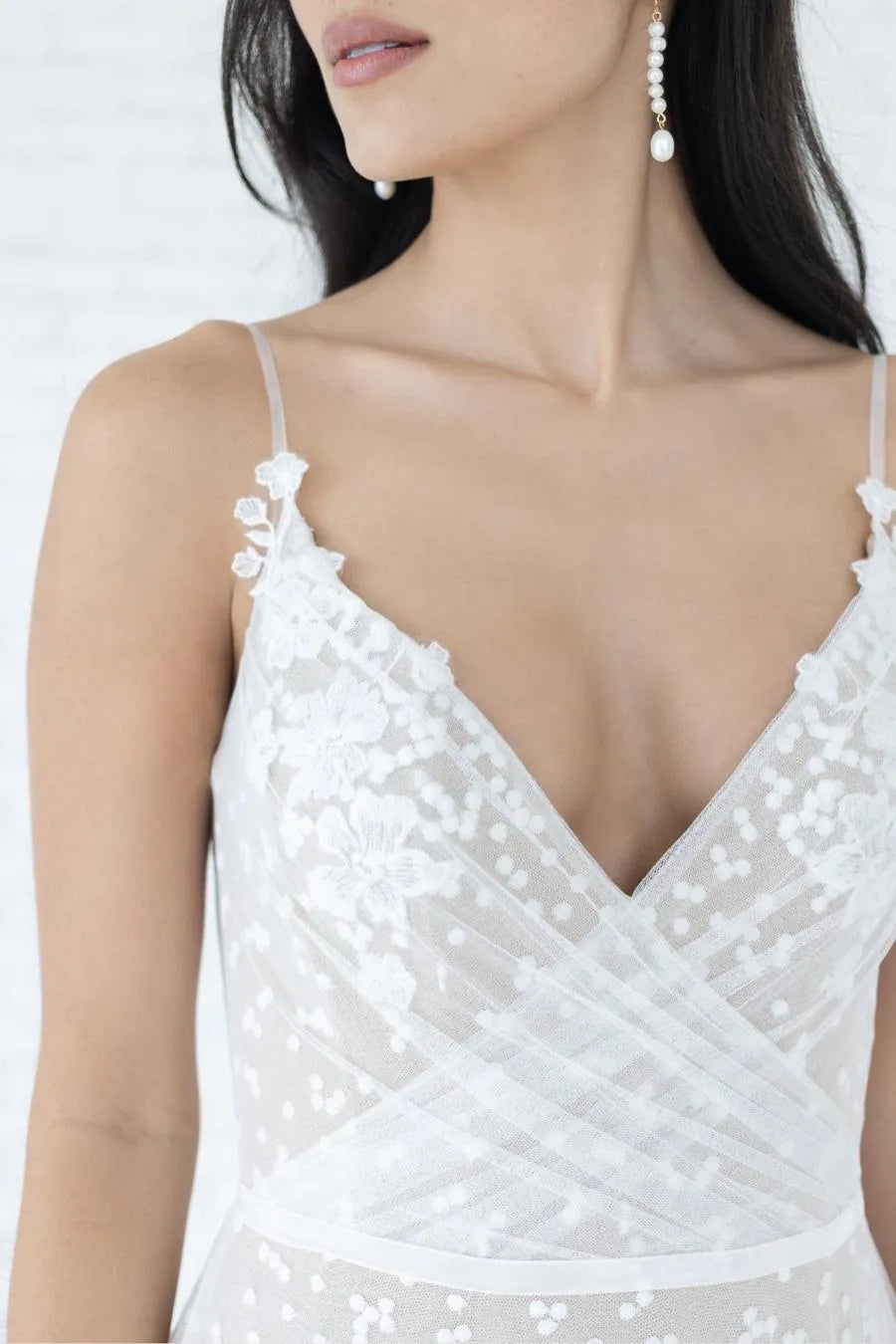 White embroidered dress with thin straps on a white background