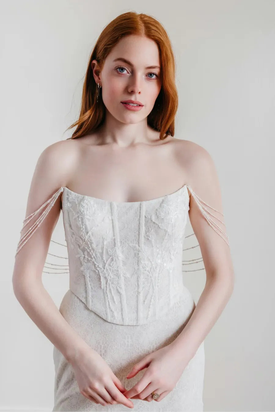 close up of willowby goldie ivory lace sheath wedding dress with a matching satin overskirt