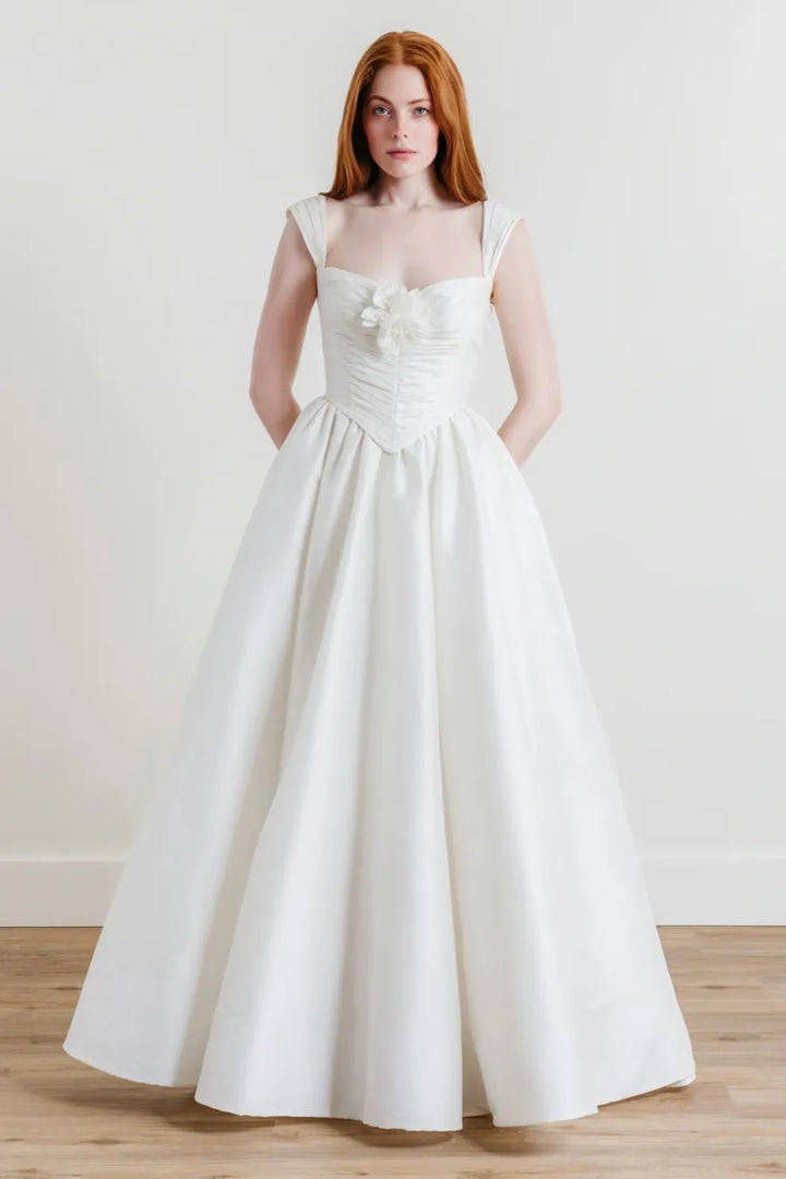 full front of willowby ingrid ivory dupioni a-line wedding dress with a drop waist and flower pin