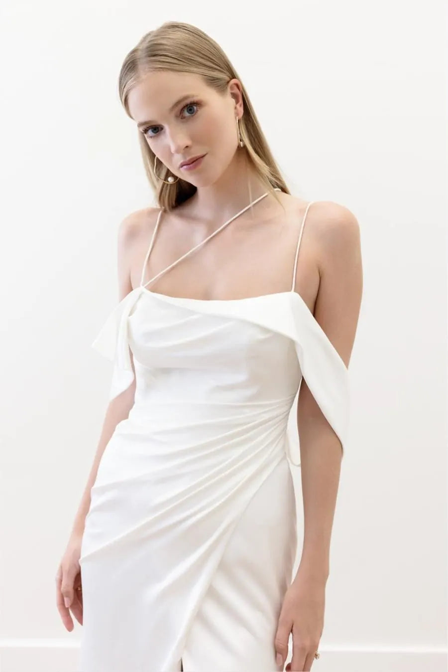 Woman wearing a white dress against a plain background
