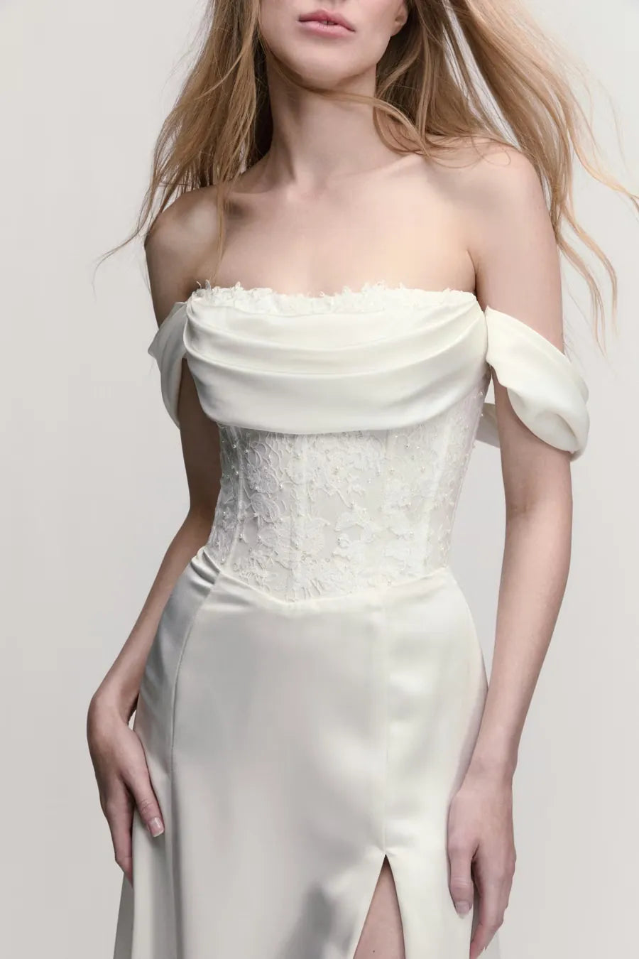 close up of willowby poppy ivory charmeuse wedding dress with detachable straps ad a high slit in the skirt