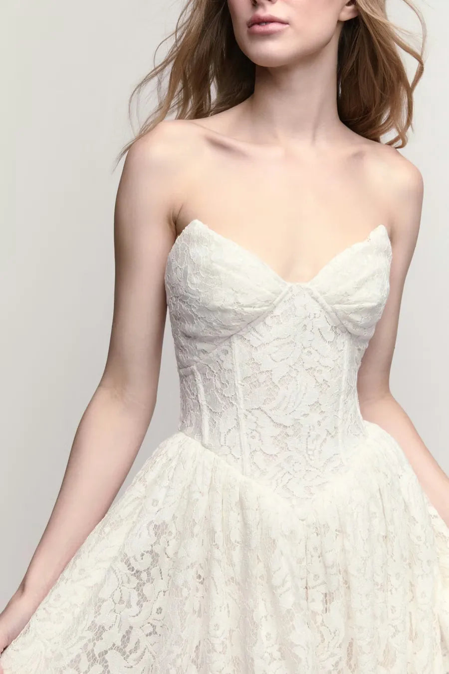 close up of willowby steffie ivory lace wedding dress with a basque waist and floral print