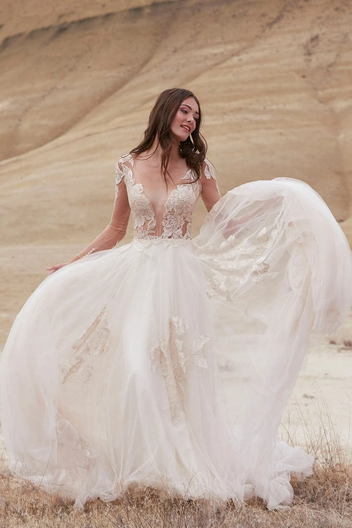 Woman in a white wedding dress standing in a desert landscape