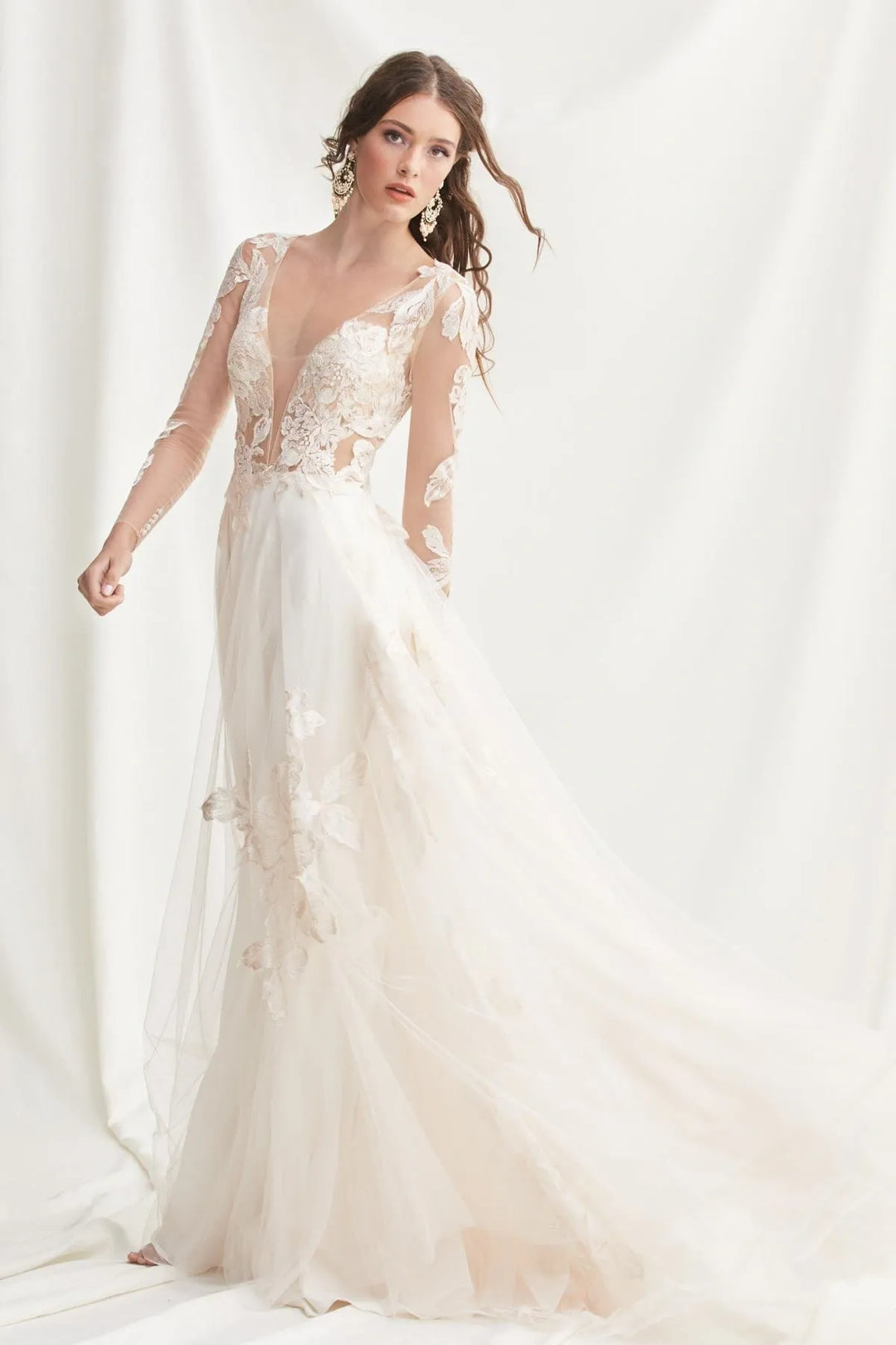 Woman wearing a white lace wedding dress against a white background