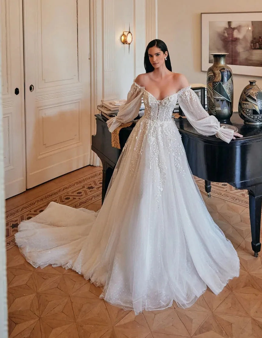 Woman in a white wedding dress standing in an elegant room with a piano and decorative items.
