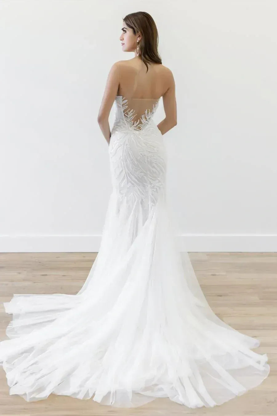 White wedding dress with open back on a wooden floor