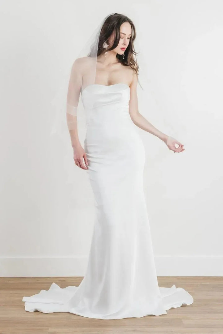 front of locket by watters dulcinea ivory satin fitted wedding dress with a strapless sweetheart neckline