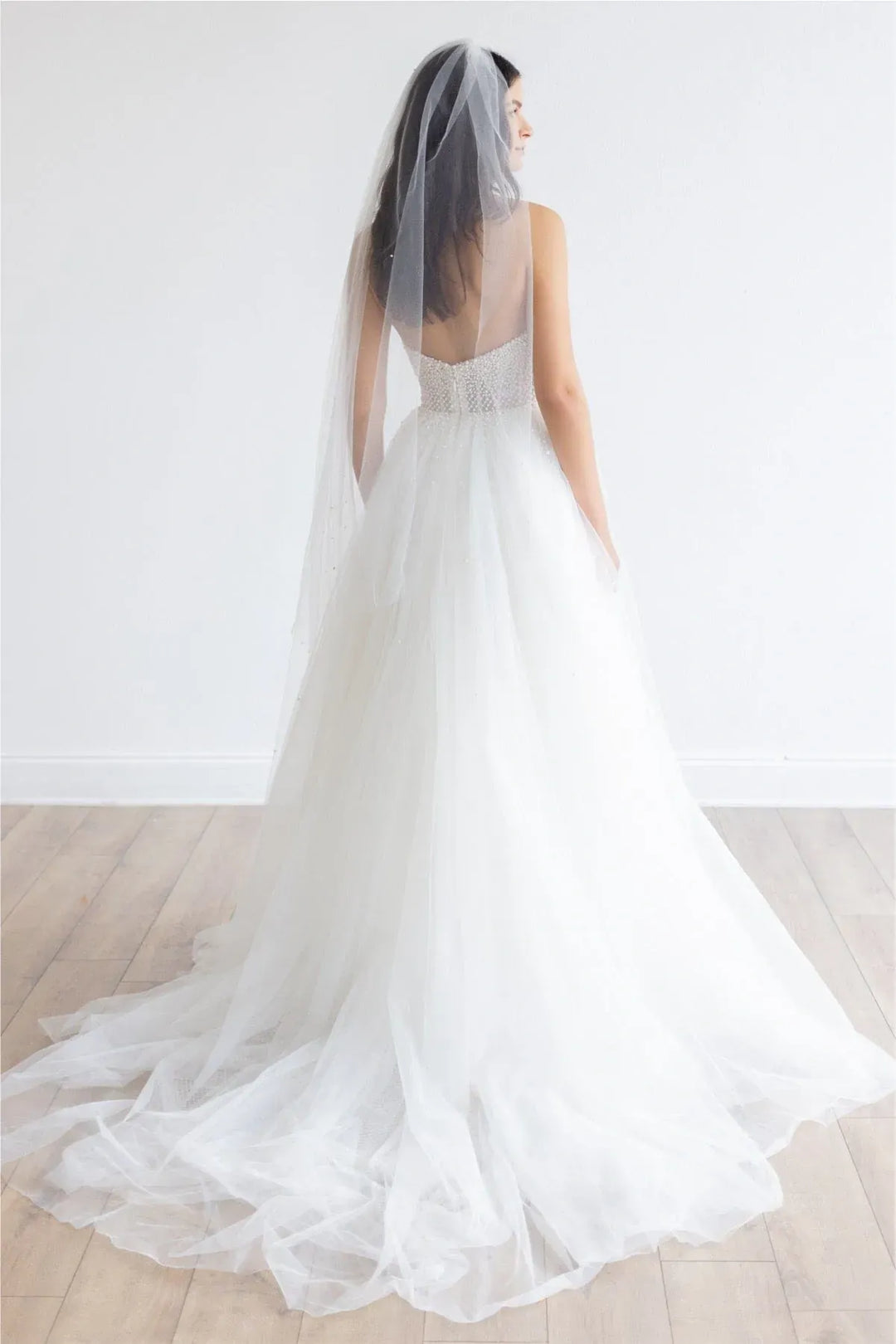 full back of locket by watters maeve ivory tulle a-line wedding dress featuring the full skirt that extends into a short train