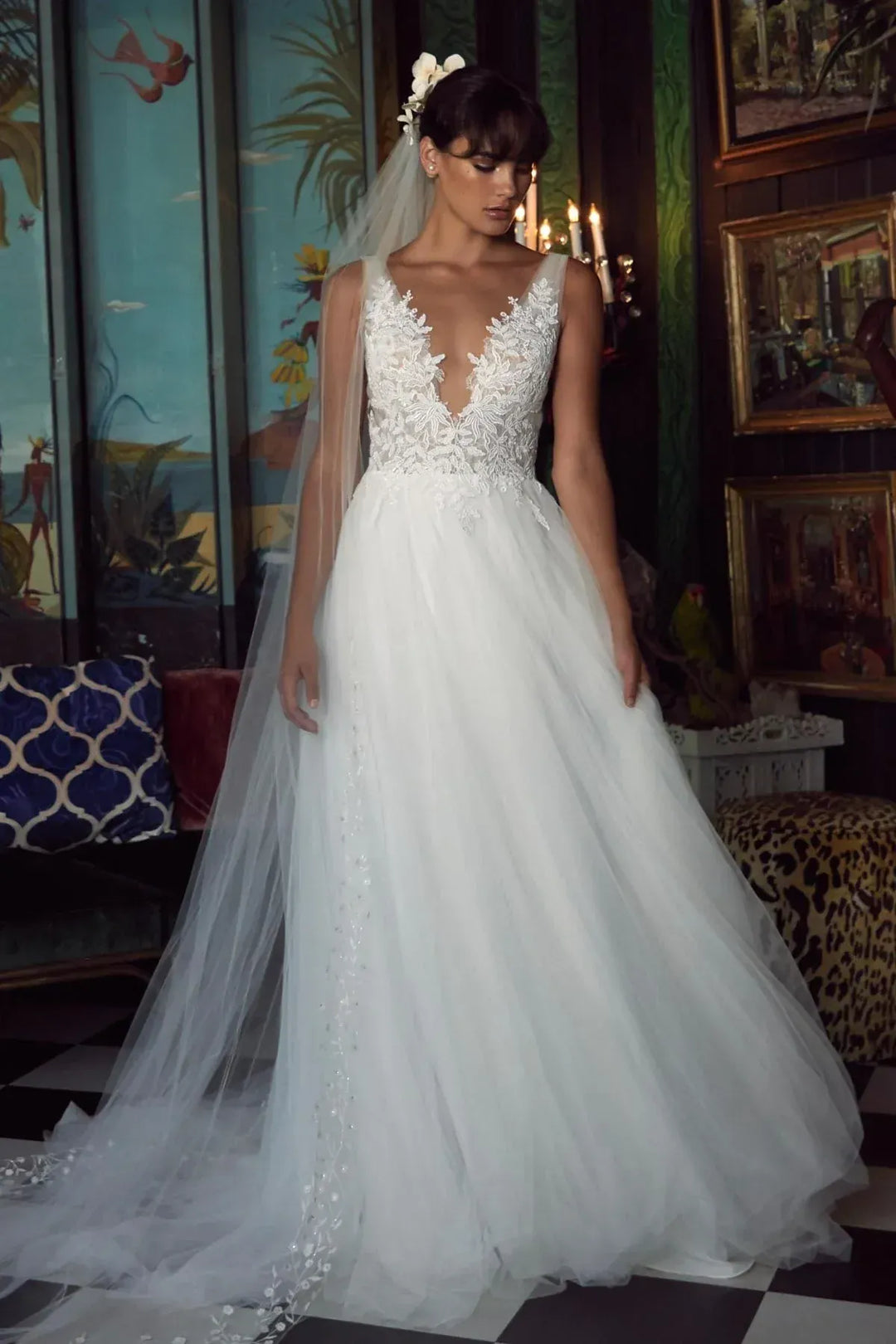 Woman in a white wedding dress with intricate detailing in an indoor setting.