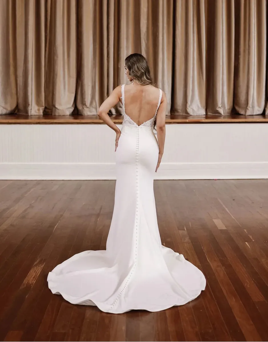 full back of zavana bridal ivory crepe fitted wedding dress featuring a square neckline and lace appliques